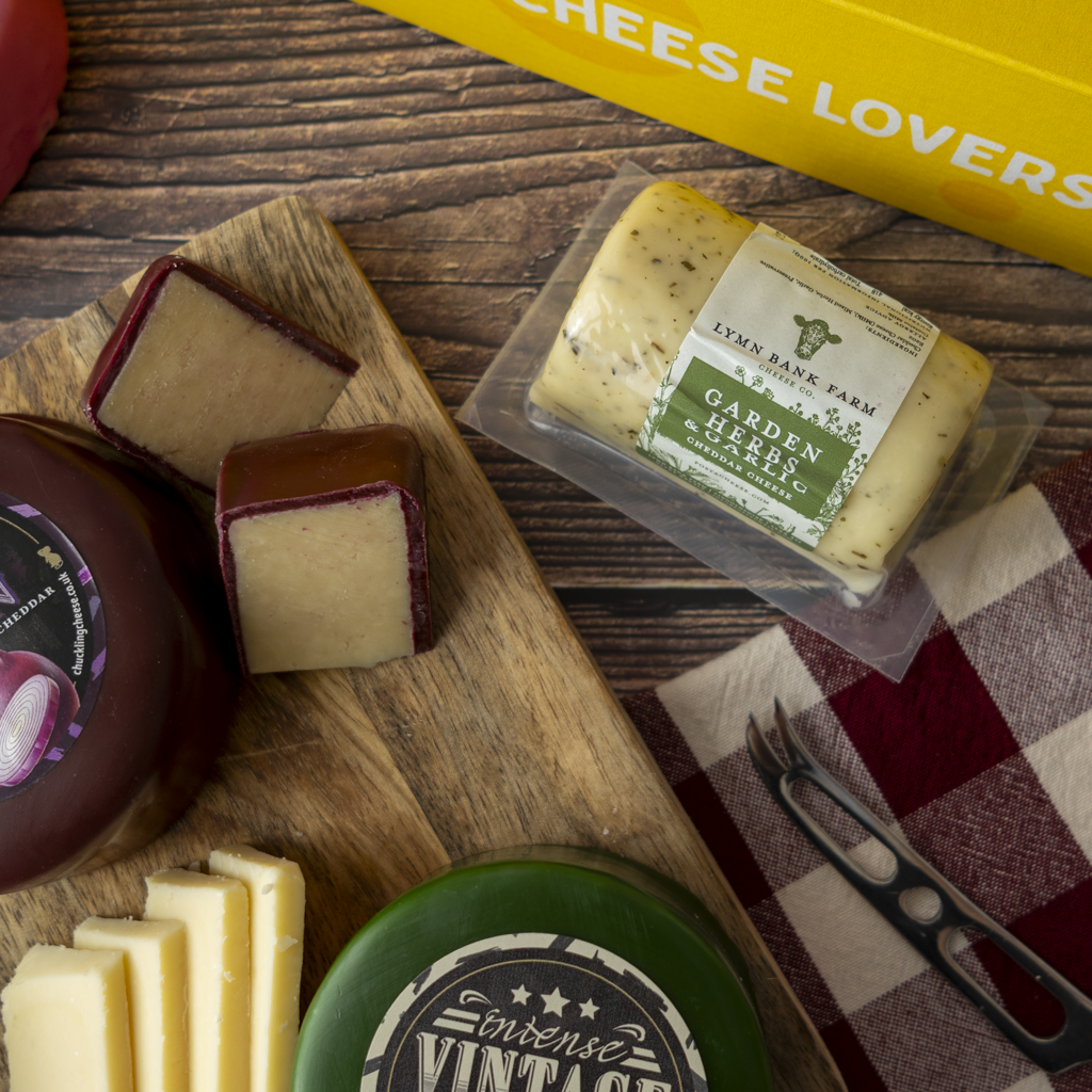 Lincolnshire Gift Box cheeseboard with Garden Herbs & Garlic Cheddar, Intense Vintage Cheddar and sliced cheese.