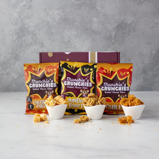 Three packages of Chuckling Cheese Munchie's Crunchies snacks on a gray background