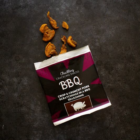 Chuckling Cheese BBQ pork scratchings packet with crispy snack pieces on a dark background