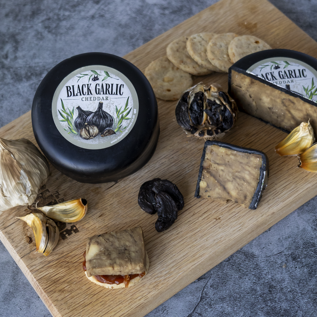 Chuckling Cheese Black Garlic Cheddar Truckle with black garlic, crackers and cheese slices