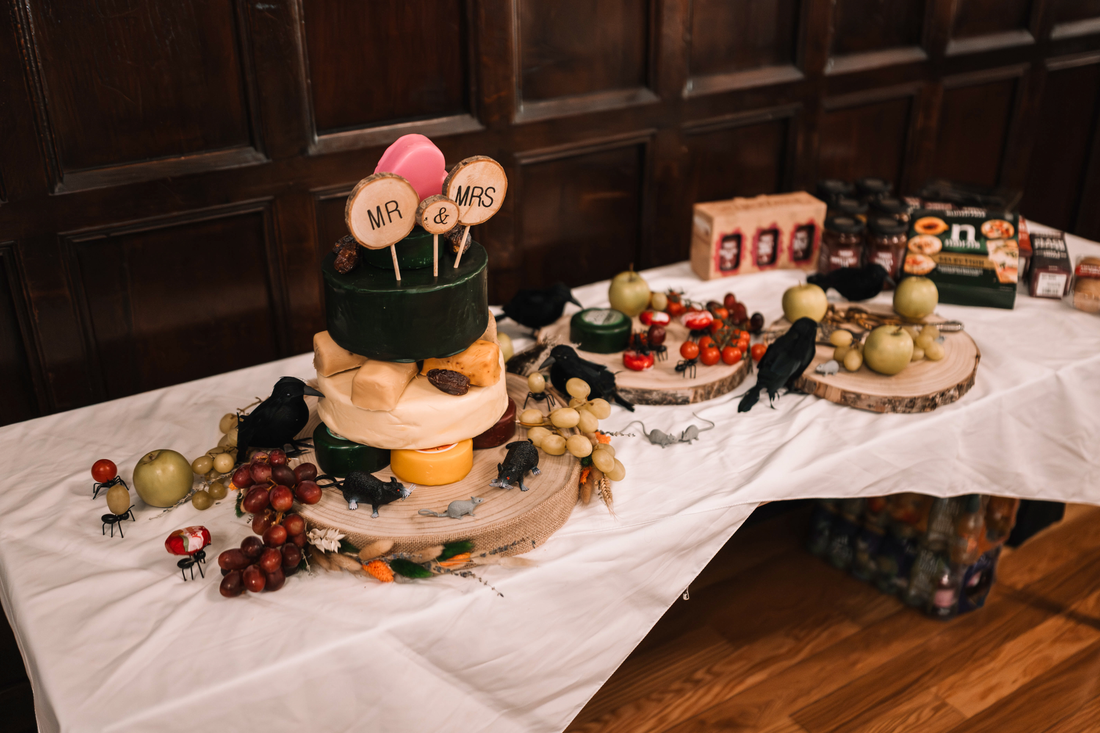 Cheese wedding cake and grazing table with assorted cheeses, fruit and accompaniments for a special event.