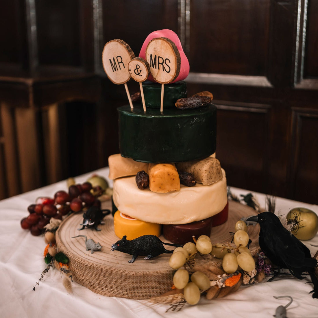 Three-tier wedding cheese cake decorated with grapes, figs and personalised Mr and Mrs toppers