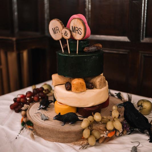 Three-tier wedding cheese cake decorated with grapes, figs and personalised Mr and Mrs toppers