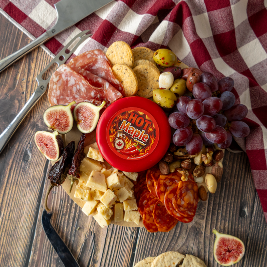 Chuckling Cheese's New Sweet and Spicy Cheese - Hot Maple Cheddar Truckle - on  a cheeseboard against a wooden background.