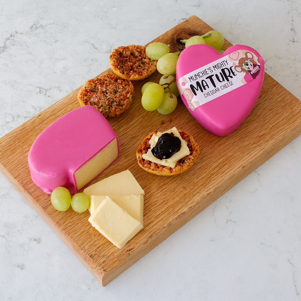 Chuckling Cheese black wax-coated cheese wheel on a white surface