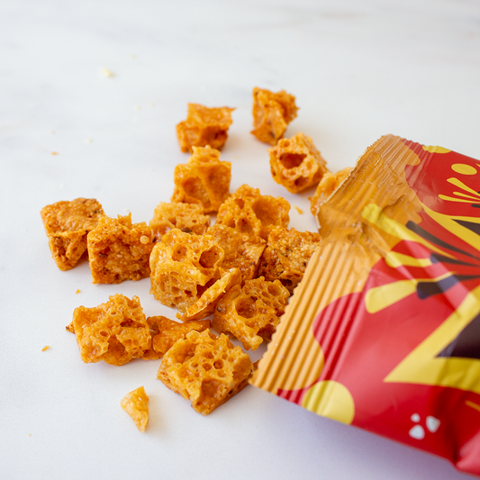 Chuckling Cheese Munchie’s Crunchies snack pieces spilling from a red and yellow packet
