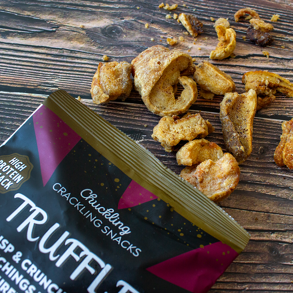 Chuckling Cheese truffle pork scratchings with crunchy snack pieces on a wooden table