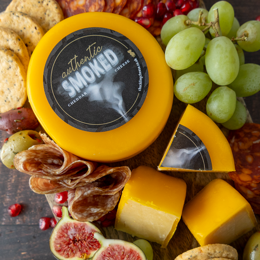 Chuckling Cheese Smoked Cheddar Truckle with grapes, crackers, cured meat, figs and sliced cheese