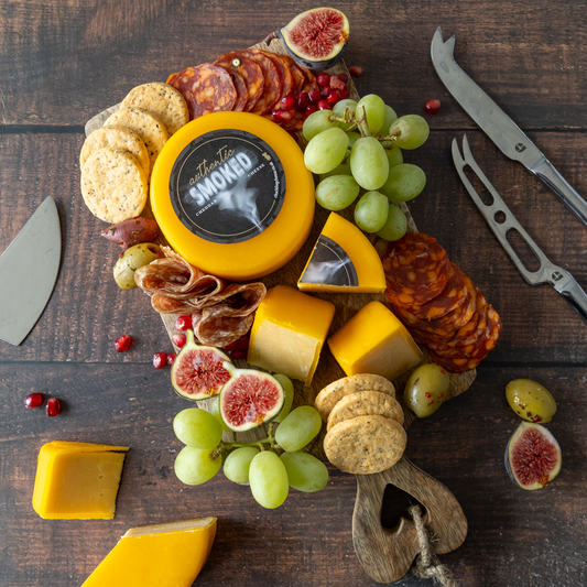 June Cheese of the Month Authentic Smoked Cheddar Cheese served on a summer cheeseboard with crackers, grapes and chutney-style pairings