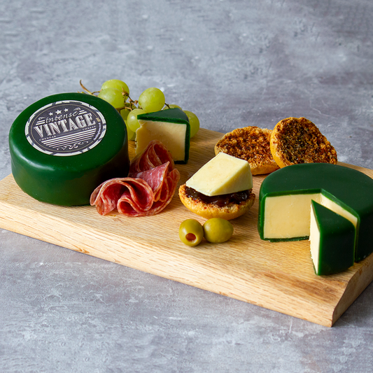Chuckling Cheese Vintage Cheddar Truckle with sliced cheddar, grapes and charcuterie