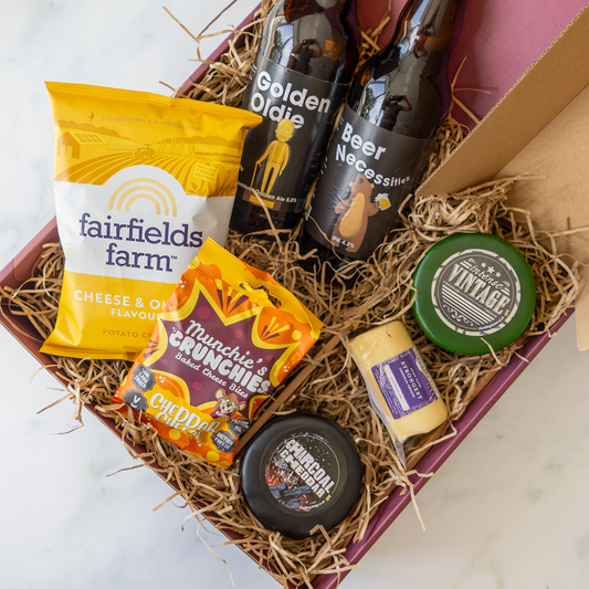 Chuckling Cheese gift hamper with cheese truckles, bottled beers, cheese and onion crisps and savoury snacks in a straw-lined box