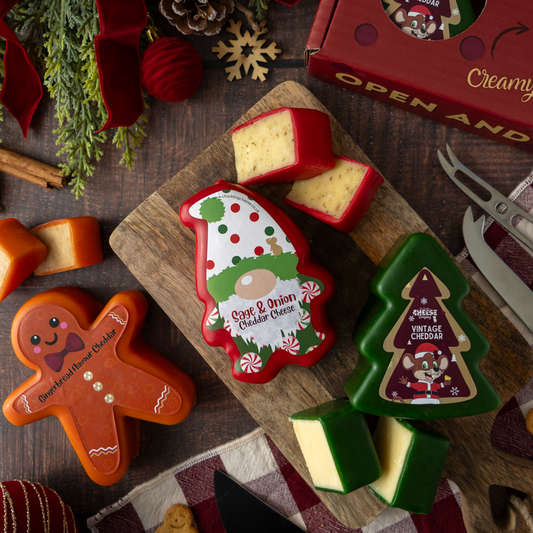 Festive Christmas cheese board with tree-shaped Vintage Cheddar, Christmas-themed cheddar cheeses and assorted cheese pieces.