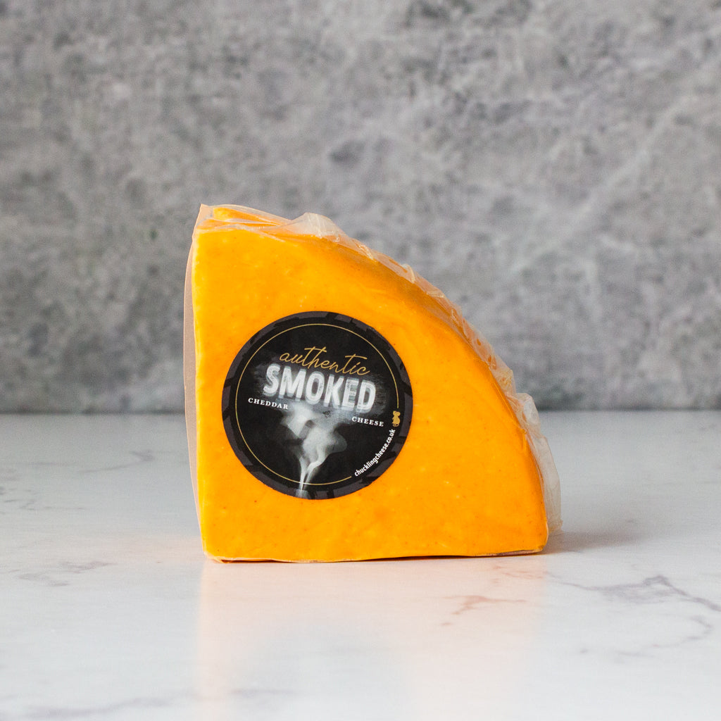 Apple Smoked Cheddar 1/4 Wheel with a label on a marble surface and gray background