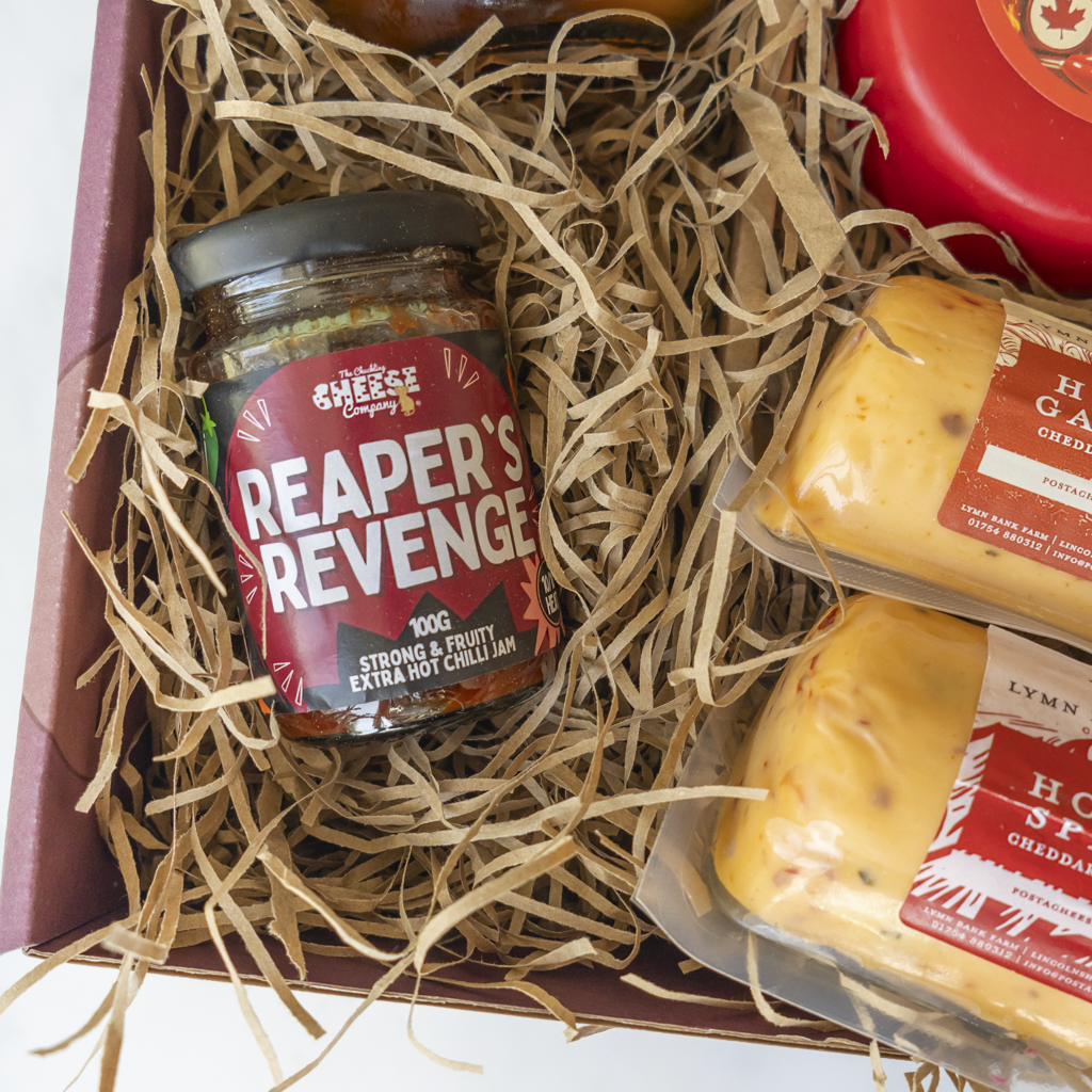 Reaper’s Revenge Extra Hot Chilli Jam close up with spicy cheddar barrels