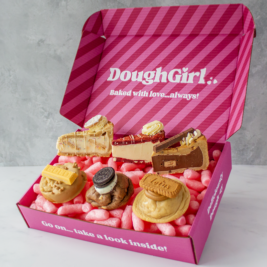Pink box of DoughGirl Congratulations Bundle with cookie pastries on a gray background