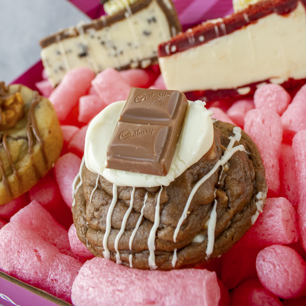Triple Chocolate Deluxe Cookie with white frosting and a Cadbury chocolate bar