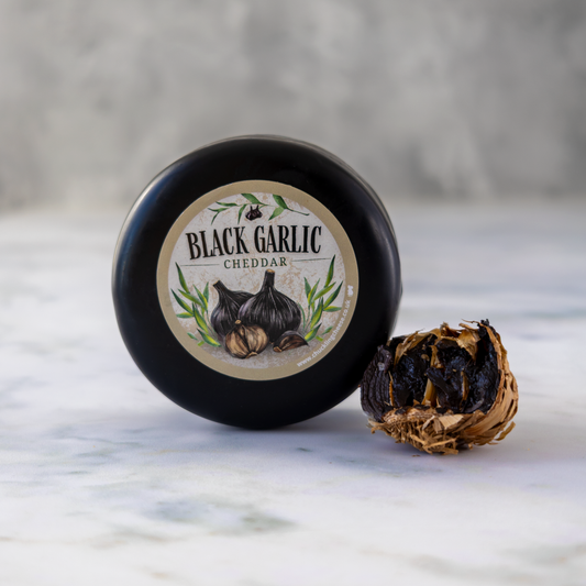 Black Garlic Cheddar Truckle beside slow-fermented black garlic