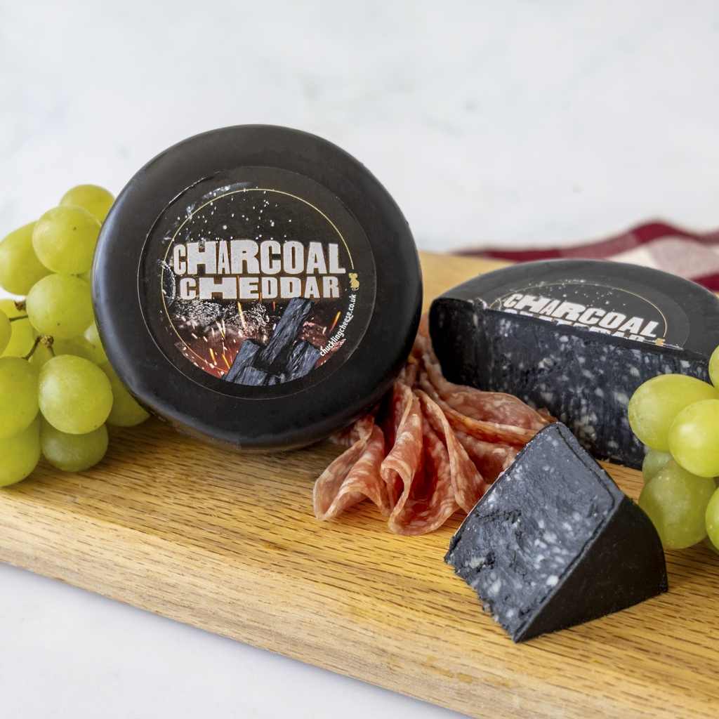 Chuckling Cheese Charcoal Cheddar Truckle with grapes, charcuterie and black cheddar wedges
