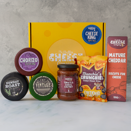 Cheese King Gift Box contents displayed with cheese truckles, mature cheddar, chutney, biscuits and cheese snacks