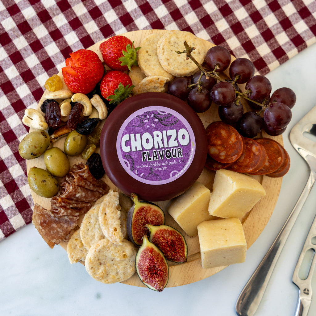 Chorizo Cheddar Truckle grazing board with grapes, tomatoes, crackers and cheese slices