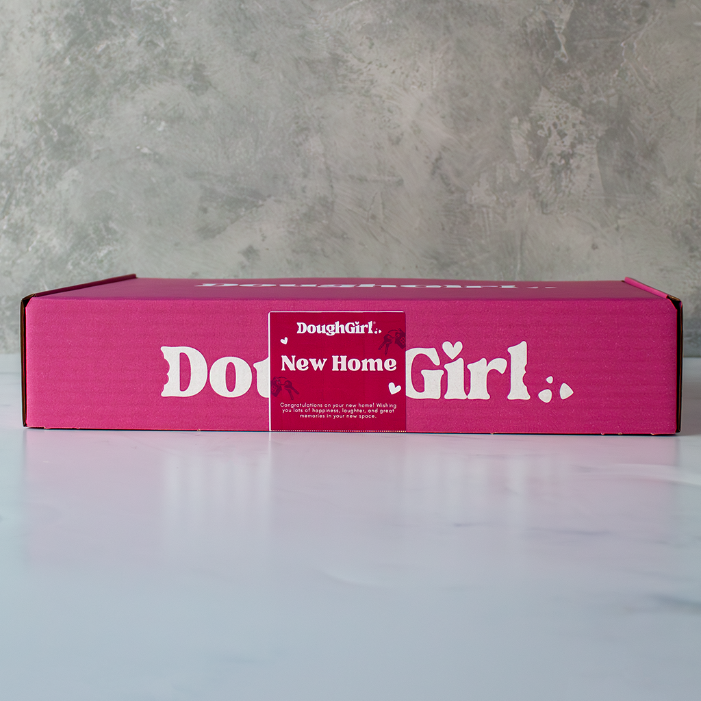 Pink box with 'DoughGirl New Home' branding on a grey surface
