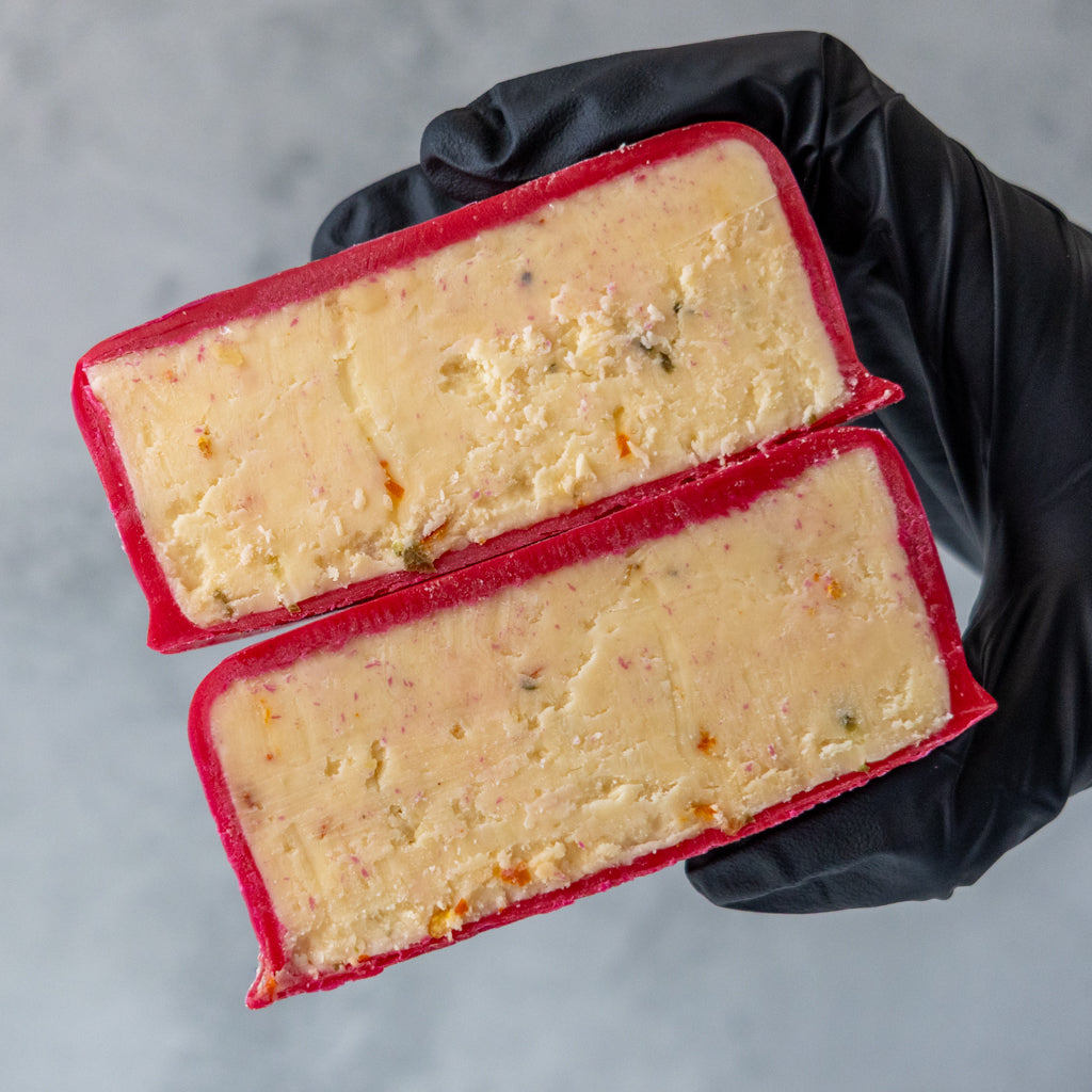 Open Hot Maple Cheddar Truckle showing sliced cheddar inside red wax