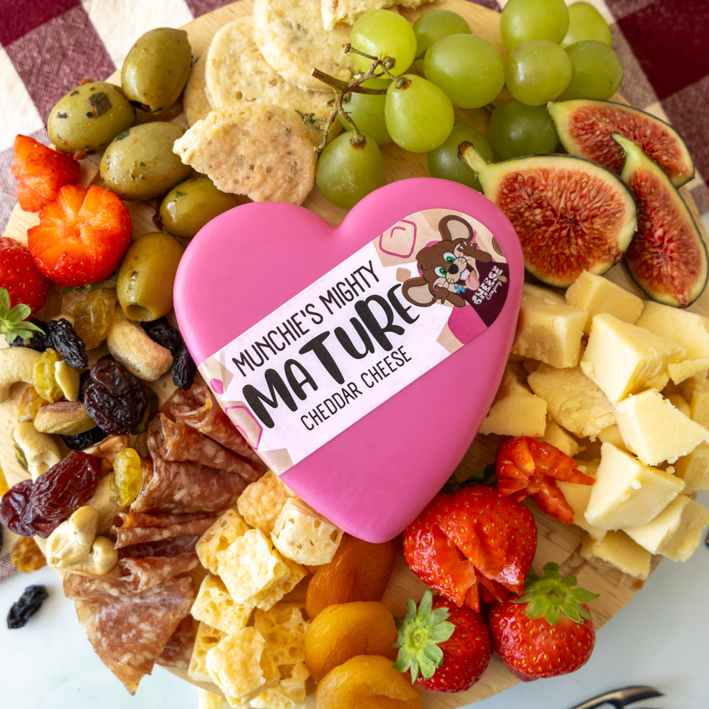 Chuckling Cheese Mighty Mature Heart Cheddar cheeseboard with grapes, crackers, figs and savoury accompaniments