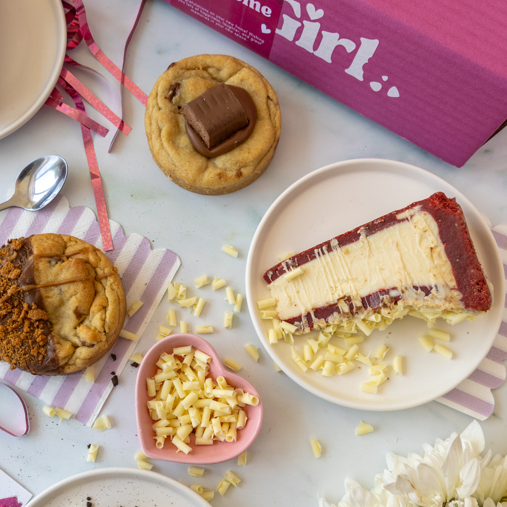 A styled flat-lay of a chocolate and cookie gift box set, featuring a pink box labeled 'DoughGirl'.