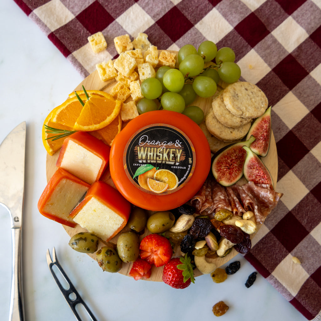 Chuckling Cheese Orange and Whiskey Cheddar Truckle grazing board with fruit, crackers and savoury accompaniments