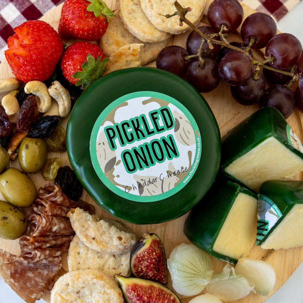 Pickled Onion Cheddar Truckle cheeseboard with crackers, grapes, olives, charcuterie and pickled onions