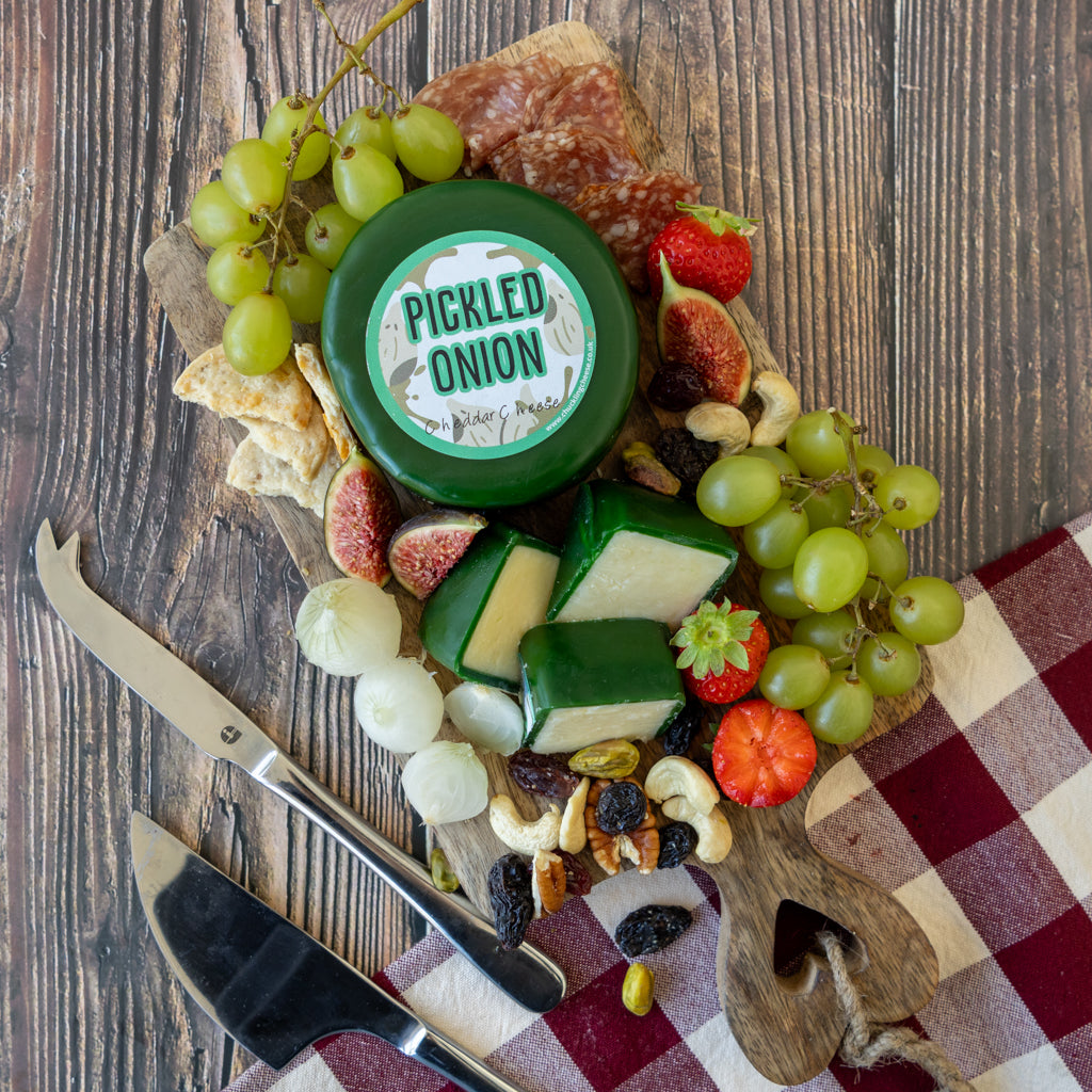 Chuckling Cheese Pickled Onion Cheddar Truckle cheeseboard with green grapes, crackers and savoury accompaniments
