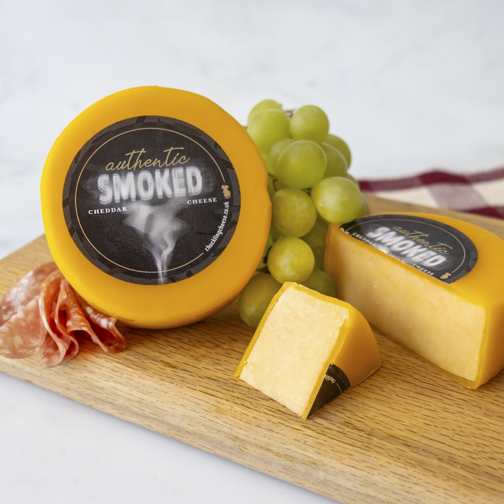 Chuckling Cheese Authentic Smoked Cheddar Truckle with grapes, charcuterie and cheese wedges
