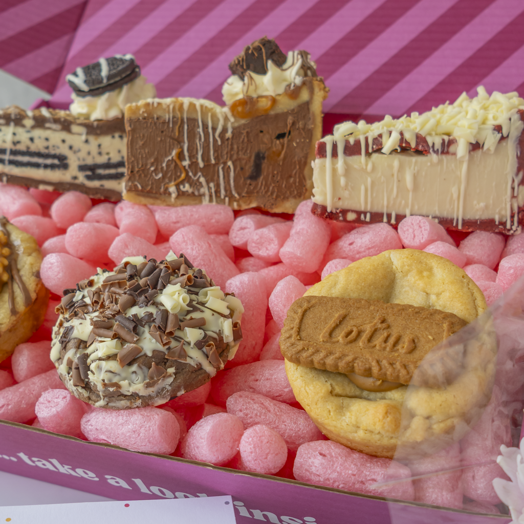 Open DoughGirl dessert gift box with assorted sweet treats and pink packaging