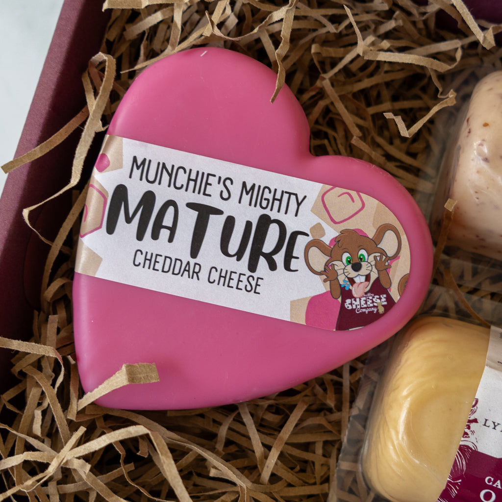 Close-up of Munchie’s Mighty Mature Cheddar heart in a cheese gift box.