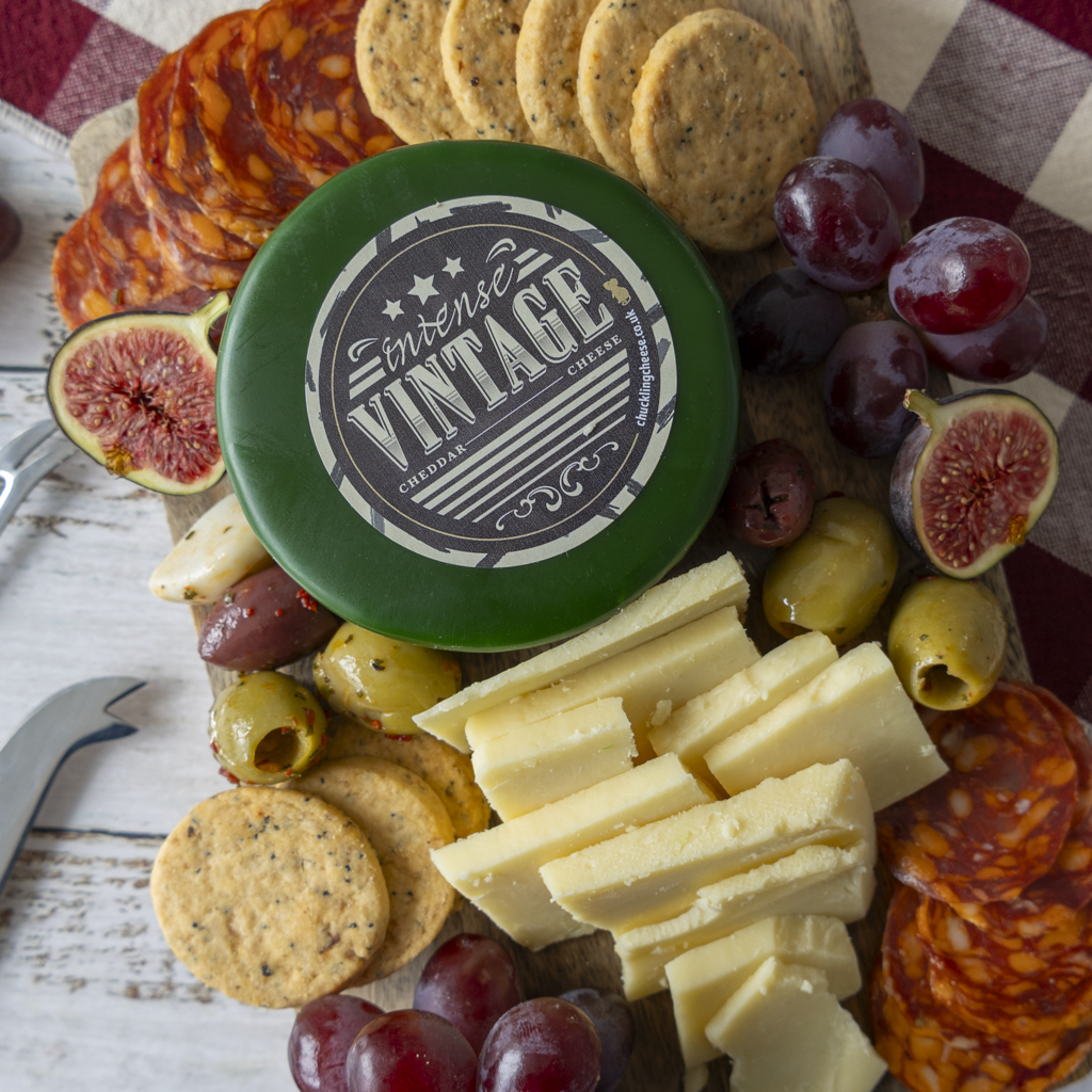 Intense Vintage Cheddar Truckle grazing board with crackers, grapes and cheese wedges