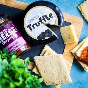 Lifestyle shot of a Truffle Cheddar Truckle with Chutney and Crackers
