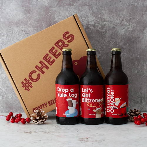 Grey background, Christmas themed image of the Christmas Comedy Beer Trio Box 2