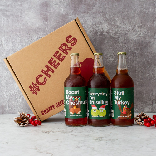 Grey background image of the Chuckling Christmas Comedy Cider Trio with 3 Christmas themed Comedy Ciders