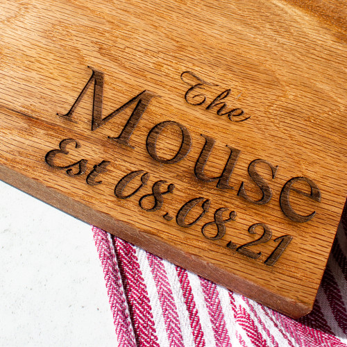 A close up image of the Engraved Family Name Chuckling Cheese Oak Cheeseboard. Personalise this cheeseboard with your chosen family name and significant date.