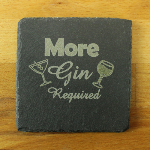 A square slate coaster by The Chuckling Cheese Company with 'more gin required' engraved on it.