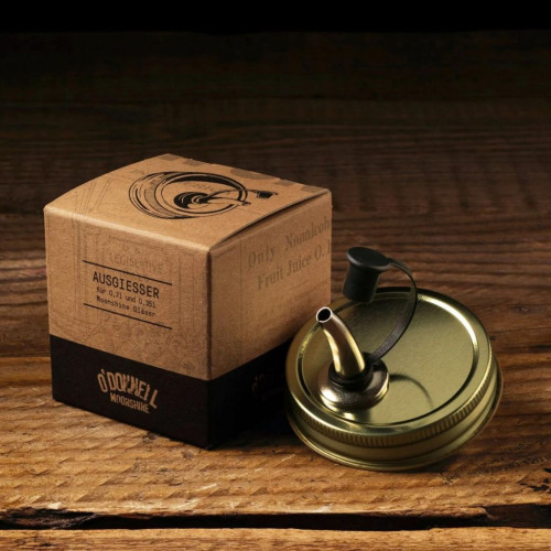Photograph of the O'Donnell Pouring Lid on a wooden background with box
