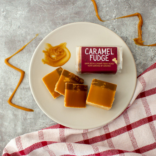 Lifestyle image of a Caramel Fudge Bar on a grey background drizzled with caramel