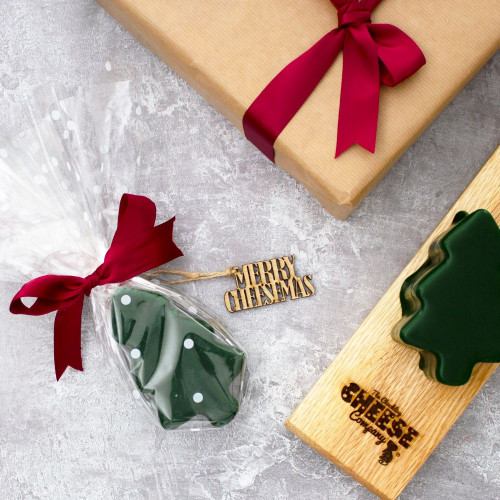 Lifestyle image of the gift wrapped christmas tree cheddar truckle in the flavour of vintage cheddar new to the chuckling cheese company for christmas 2022.