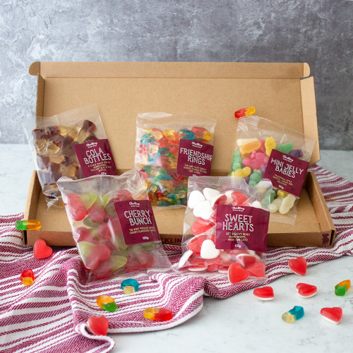 A close up image of the Congratulations Sweet Letterbox Gift by The Chuckling Cheese Company which includes cherry bunchs, cola bottles, sweet hearts, friendship rings and mini jelly babies