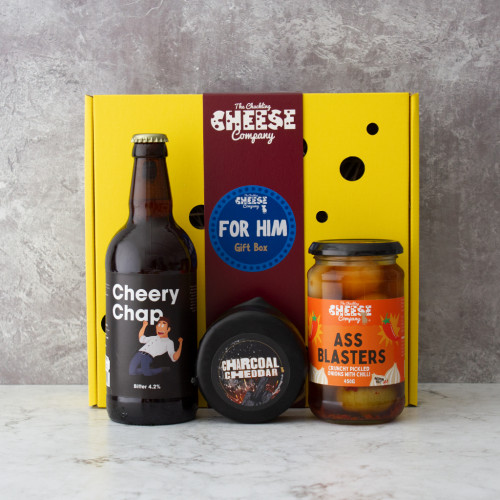 A grey background image of the For Him Gift Box including a comedy beer, charcoal cheddar cheese truckle, and a jar of pickled onions.