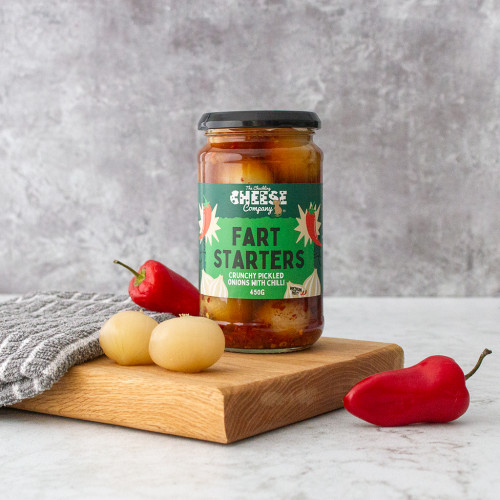 A lifestyle image of a jar of fart starter pickled onions by the chuckling cheese company