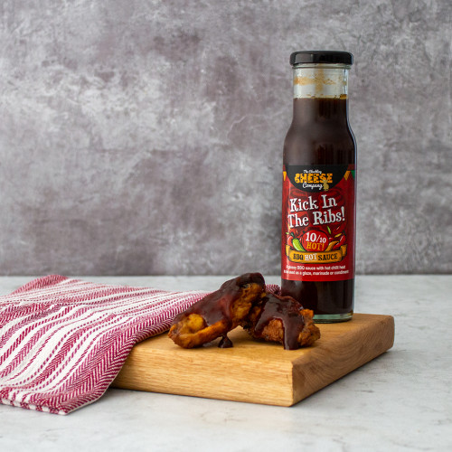 Chuckling Kick in the Ribs Hot Sauce served with chicken wings, available at The Chuckling Cheese Company. Shop our range of chilli sauces and jams today!