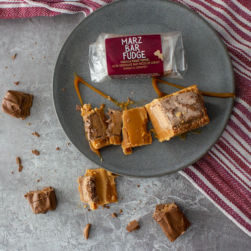 Lifestyle image of the Marz Bar Fudge Bar on a plate drizzled with caramel sauce