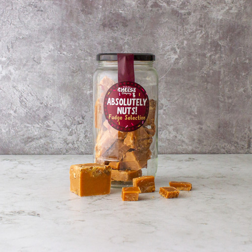 A grey background image of a glass jar of Chuckling Cheese Nutty Fudge Selection.