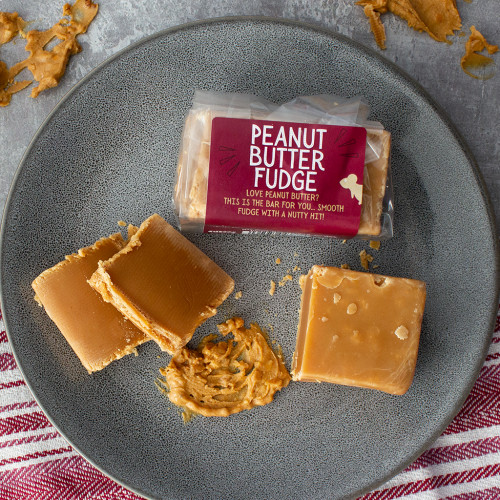 Lifestyle image of a bar of Peanut Butter Fudge decorated with peanut butter